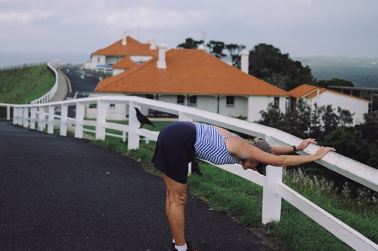 A woman stretches on a scenic road near Cape Byron Lighthouse in Byron Bay, Australia.